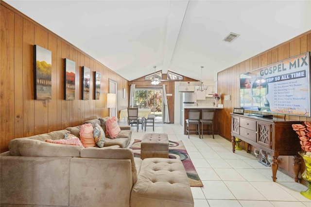 living area with light tile patterned floors, wooden walls, visible vents, a ceiling fan, and lofted ceiling with beams