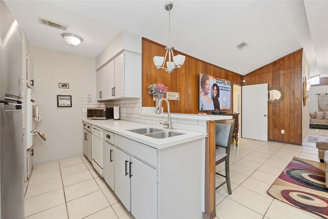 kitchen featuring a sink, a kitchen bar, white cabinets, and light countertops