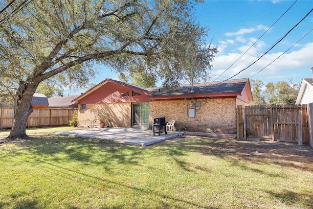 back of house featuring a patio area, brick siding, a fenced backyard, and a lawn