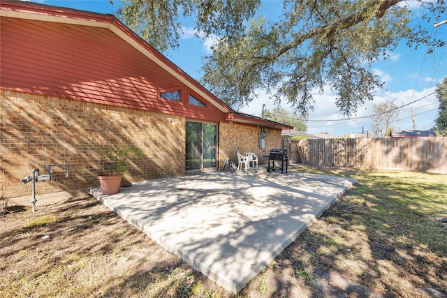 view of patio featuring a grill and fence