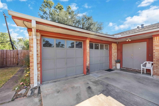 garage with driveway and fence