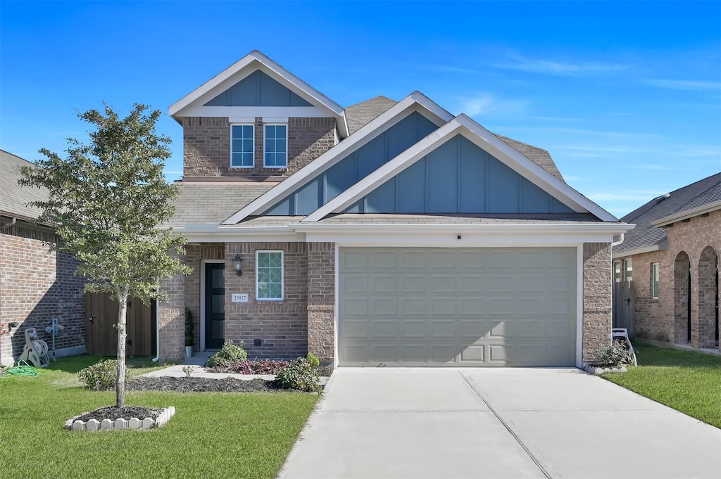 view of front facade with board and batten siding, a front yard, concrete driveway, and a garage