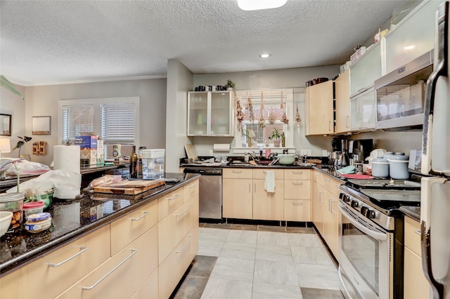 kitchen featuring a textured ceiling, appliances with stainless steel finishes, glass insert cabinets, and dark stone countertops