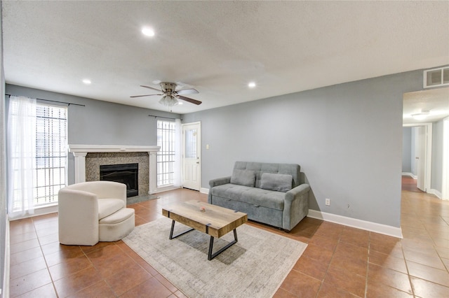 tiled living area with recessed lighting, visible vents, baseboards, and a premium fireplace