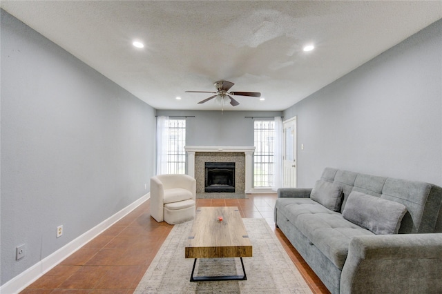 living area featuring tile patterned flooring, recessed lighting, a fireplace with flush hearth, a ceiling fan, and baseboards