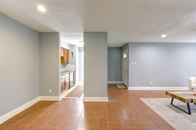 interior space featuring recessed lighting, a textured ceiling, baseboards, and light tile patterned floors