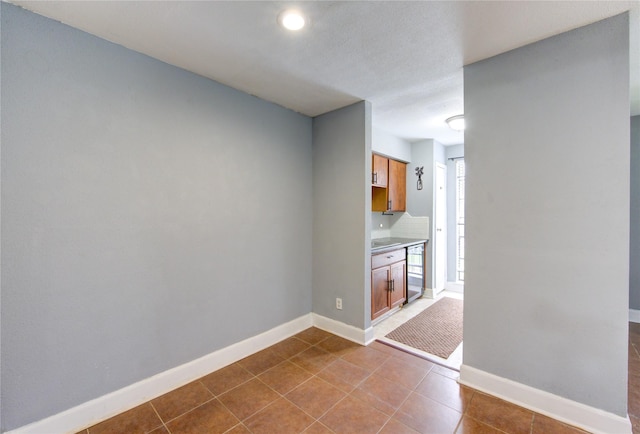 interior space with dark tile patterned floors and baseboards