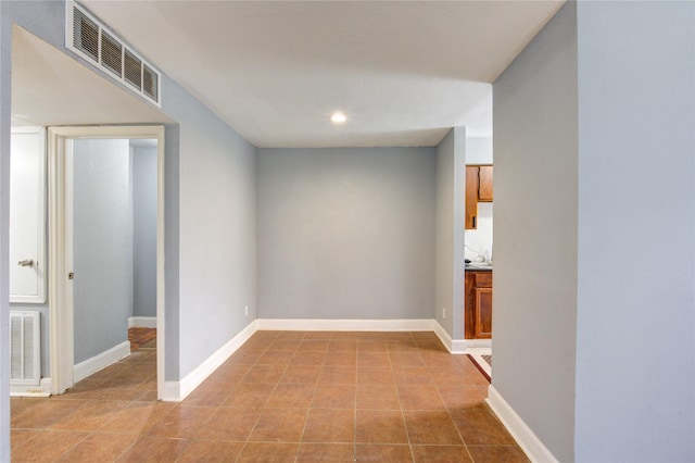 corridor featuring light tile patterned flooring, visible vents, and baseboards