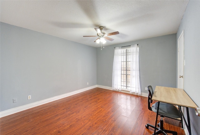 office area with a ceiling fan, a textured ceiling, baseboards, and wood finished floors