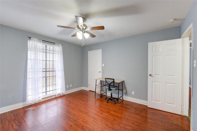 spare room featuring wood finished floors, a ceiling fan, and baseboards