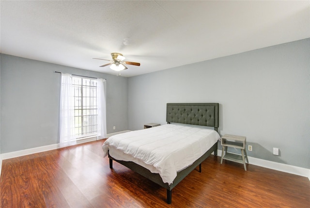 bedroom featuring ceiling fan, baseboards, and wood finished floors