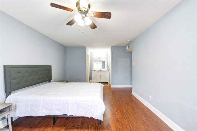 bedroom with visible vents, a ceiling fan, ensuite bath, wood finished floors, and baseboards