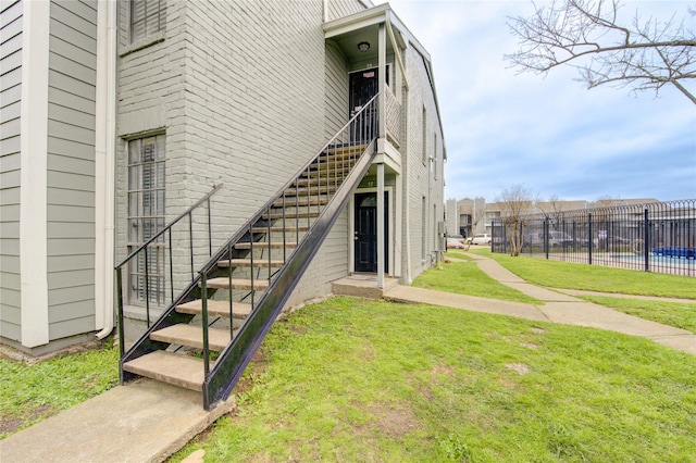 view of property featuring stairs and fence