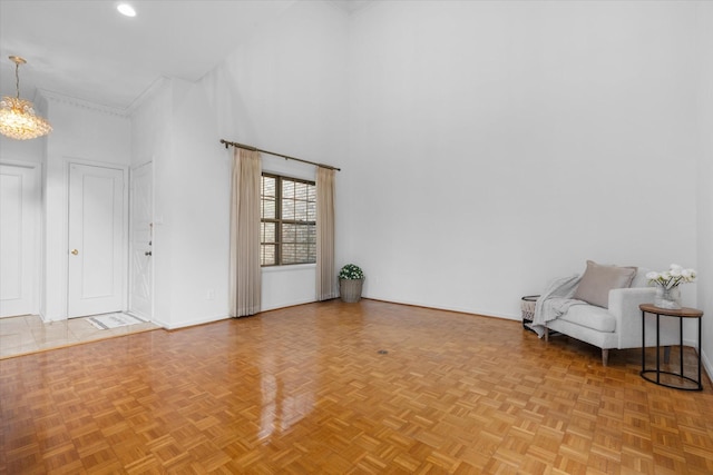 interior space with a high ceiling, baseboards, and a chandelier