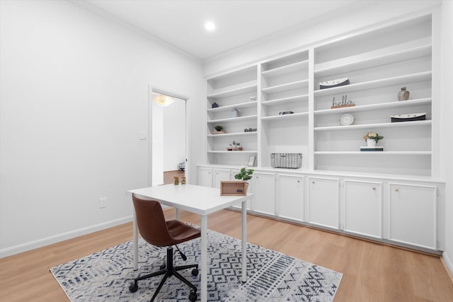 office area with built in features, light wood-type flooring, and baseboards