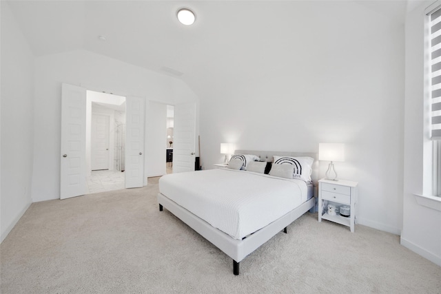 bedroom with lofted ceiling and light carpet