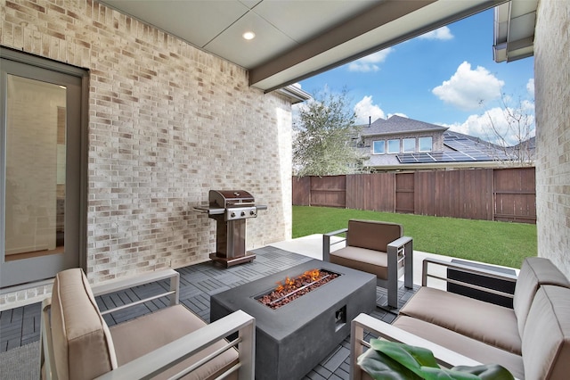 view of patio / terrace featuring area for grilling, an outdoor living space with a fire pit, and fence