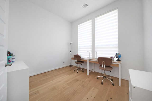 office featuring light wood finished floors, visible vents, and baseboards