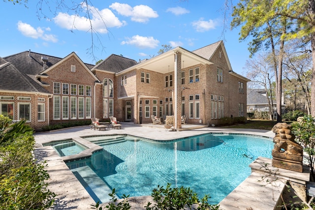 view of pool with a patio area and a pool with connected hot tub