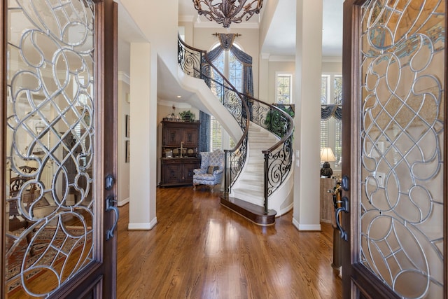 entryway with baseboards, stairway, crown molding, and wood finished floors