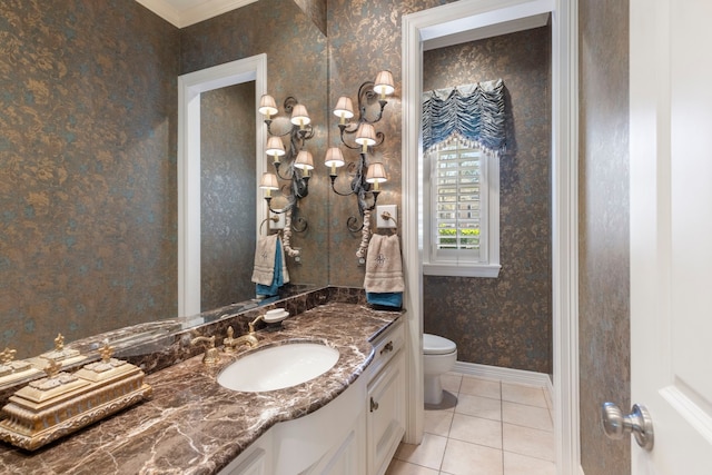 bathroom with tile patterned flooring, toilet, vanity, baseboards, and wallpapered walls