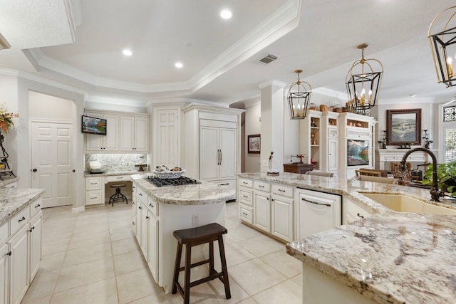 kitchen with visible vents, a raised ceiling, a center island, white dishwasher, and a sink