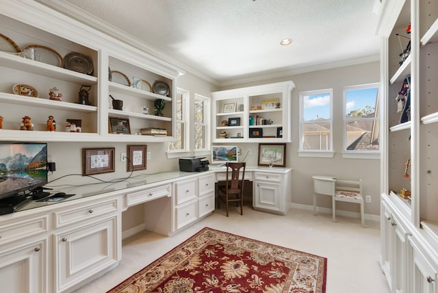 home office featuring crown molding, built in desk, light colored carpet, a textured ceiling, and baseboards