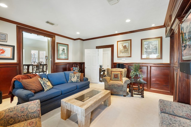 living area featuring wainscoting, ornamental molding, and light colored carpet