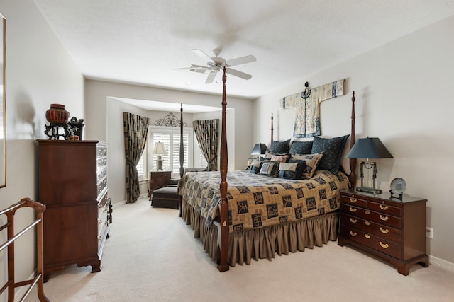 bedroom featuring light carpet, ceiling fan, a textured ceiling, and baseboards