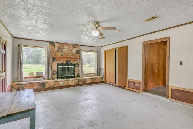 unfurnished living room with plenty of natural light, a fireplace, visible vents, and unfinished concrete floors