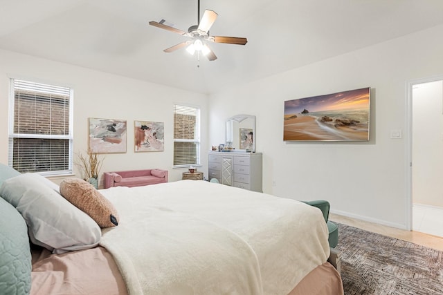 carpeted bedroom featuring vaulted ceiling, a ceiling fan, and baseboards