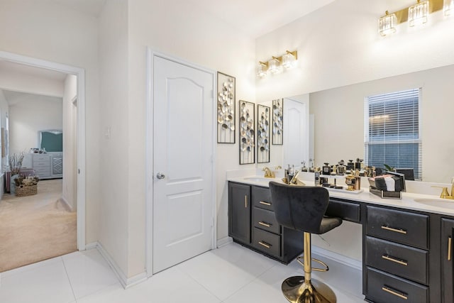 full bath with double vanity, tile patterned flooring, baseboards, and a sink