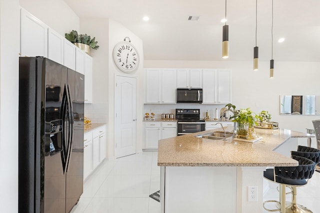 kitchen with white cabinets, electric range, a breakfast bar, and black fridge