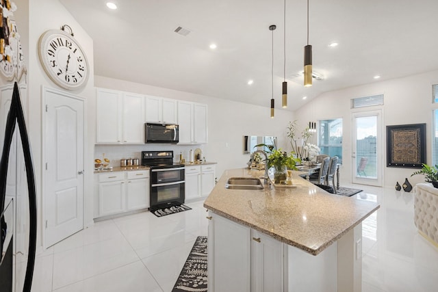 kitchen with a sink, white cabinets, double oven range, an island with sink, and decorative light fixtures