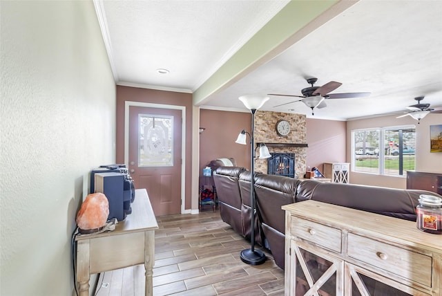 5826 Russell Ln, Baytown, TX 77521 - living area featuring a textured wall, a stone fireplace, wood finish floors, baseboards, and crown molding