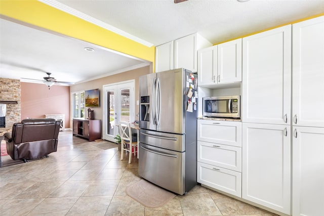 5826 Russell Ln, Baytown, TX 77521 - kitchen with ornamental molding, white cabinetry, stainless steel appliances, and open floor plan