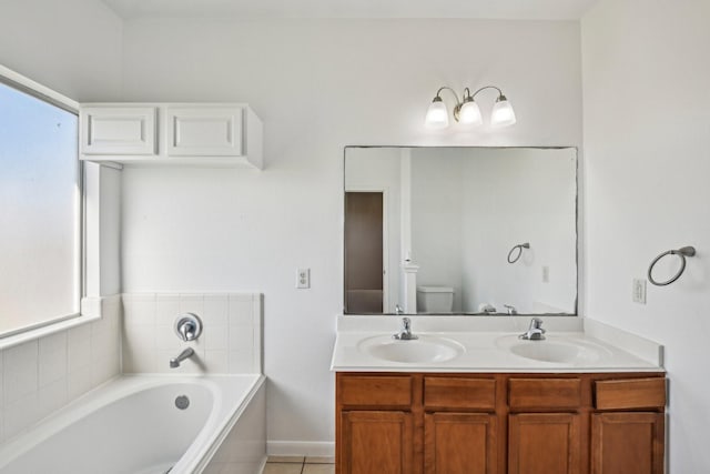 full bath with a garden tub, a sink, toilet, and double vanity