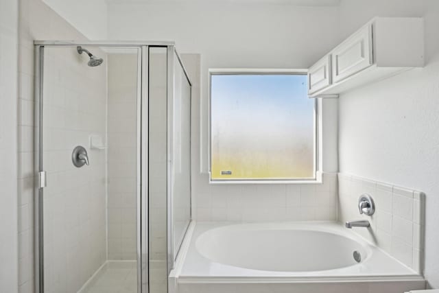 bathroom featuring a stall shower and a garden tub