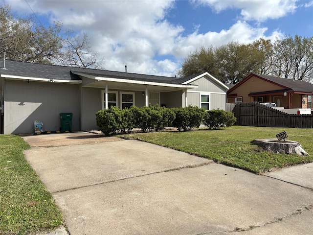 view of front of home featuring driveway, a front yard, and fence