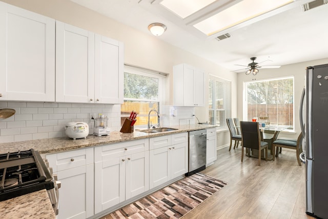 kitchen featuring visible vents, appliances with stainless steel finishes, a sink, and white cabinetry