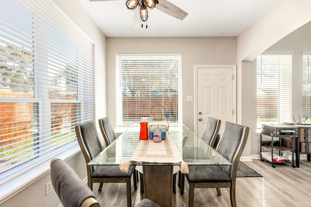 dining area featuring light wood-type flooring, ceiling fan, and baseboards