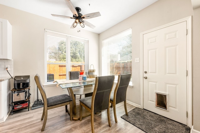 dining space featuring ceiling fan, light wood-type flooring, and baseboards