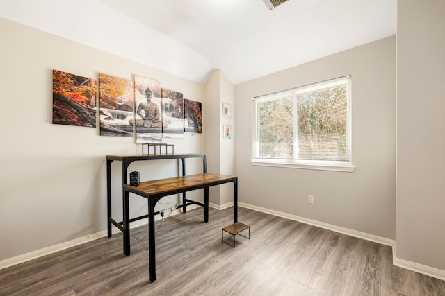 office space with lofted ceiling, visible vents, baseboards, and wood finished floors