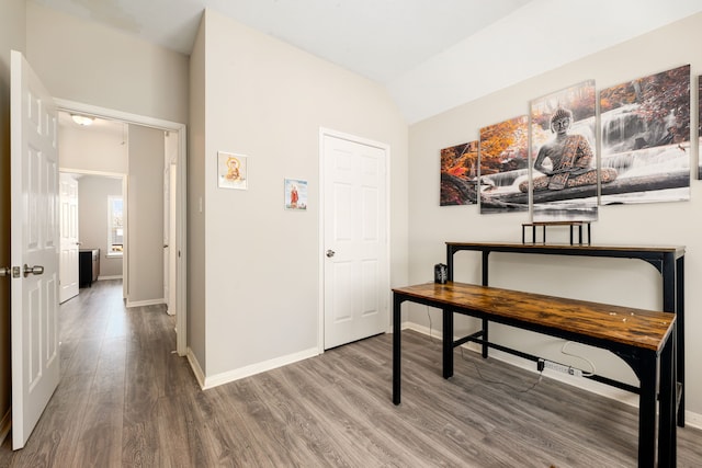 office with lofted ceiling, baseboards, and wood finished floors