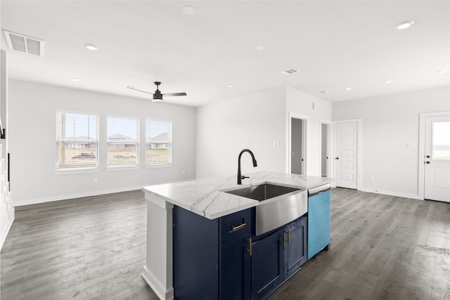 kitchen with a center island with sink, visible vents, blue cabinets, a sink, and stainless steel dishwasher