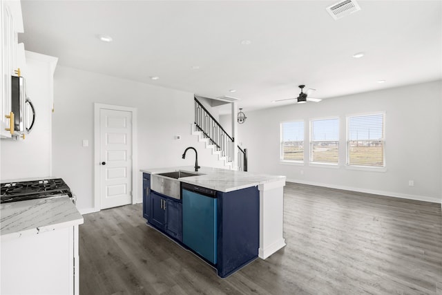 kitchen with a center island with sink, visible vents, white cabinets, appliances with stainless steel finishes, and light stone counters