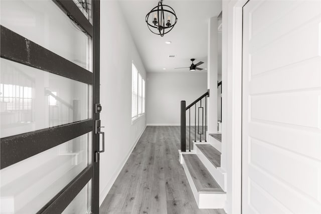 foyer entrance with recessed lighting, ceiling fan with notable chandelier, baseboards, stairway, and light wood-type flooring