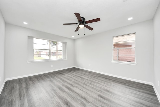 spare room featuring a ceiling fan, recessed lighting, dark wood finished floors, and baseboards