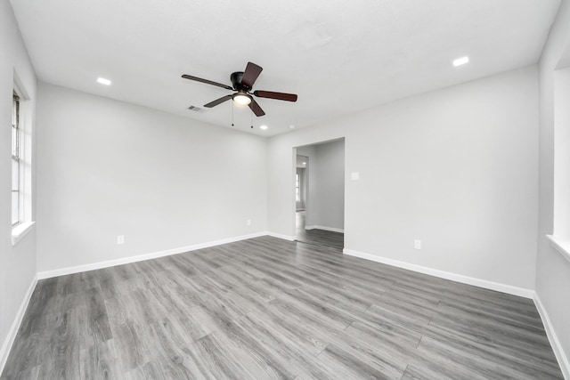 empty room with recessed lighting, ceiling fan, light wood-style flooring, and baseboards