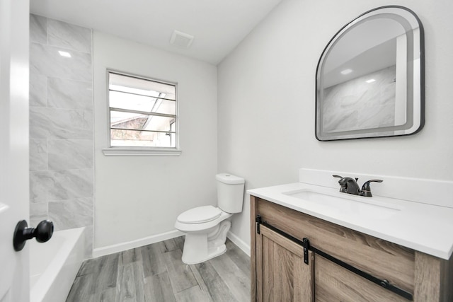 full bathroom with toilet, washtub / shower combination, vanity, wood finished floors, and baseboards